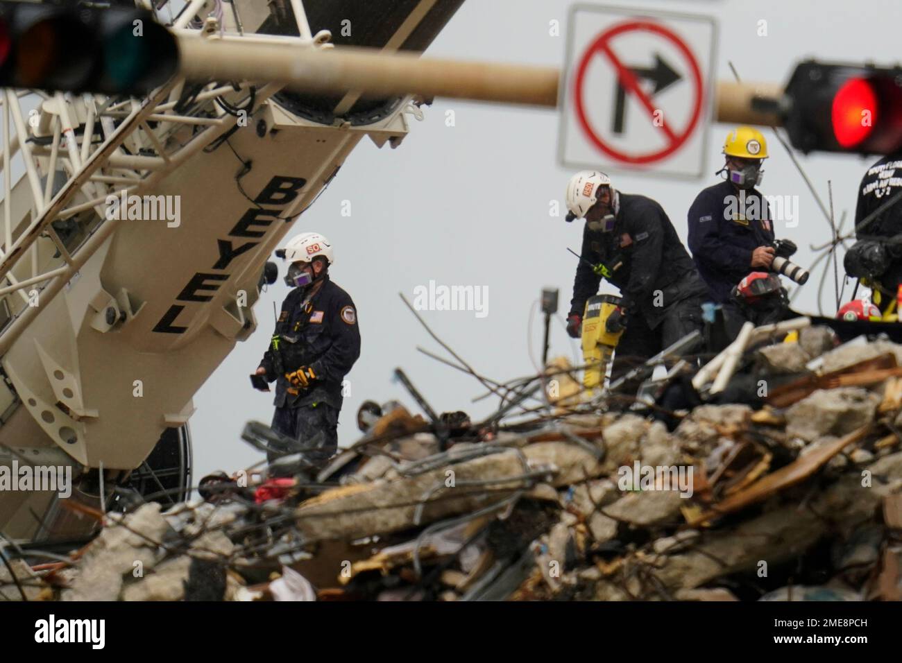 Search and rescue personnel work atop the rubble at the Champlain ...