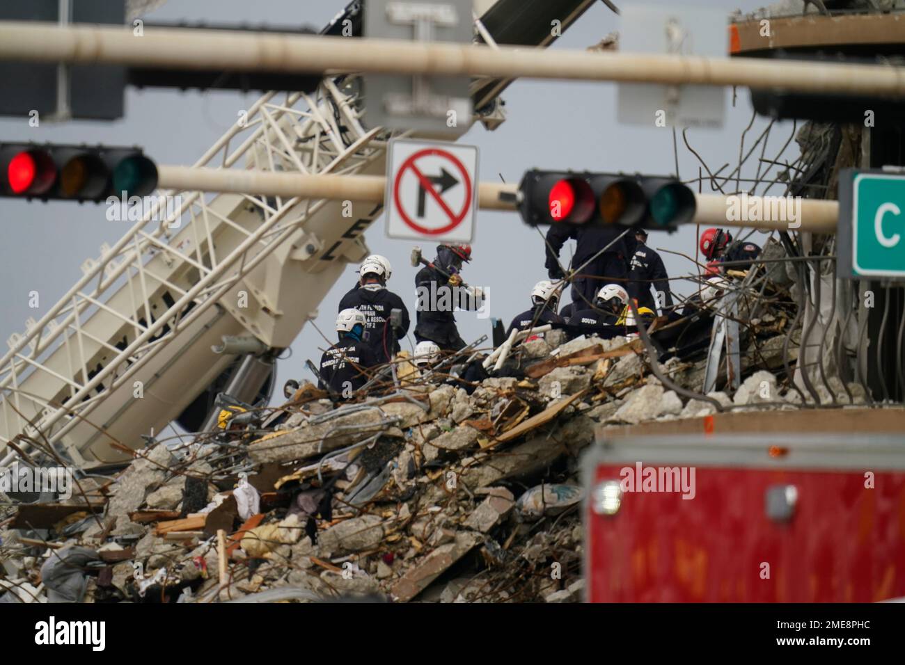 Search and rescue personnel work atop the rubble at the Champlain ...