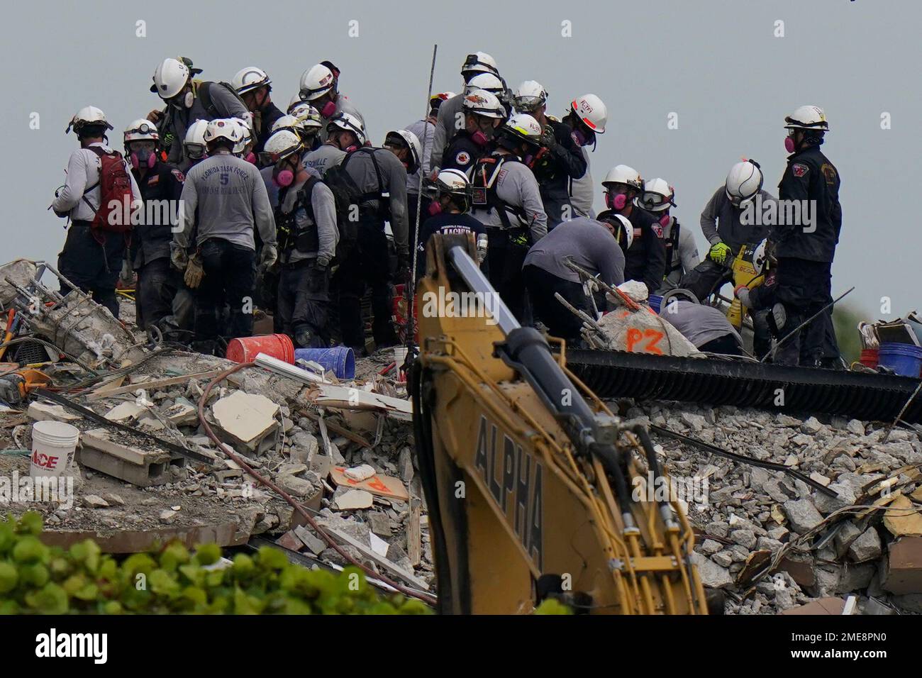 Search and rescue personnel work atop the rubble at the Champlain ...