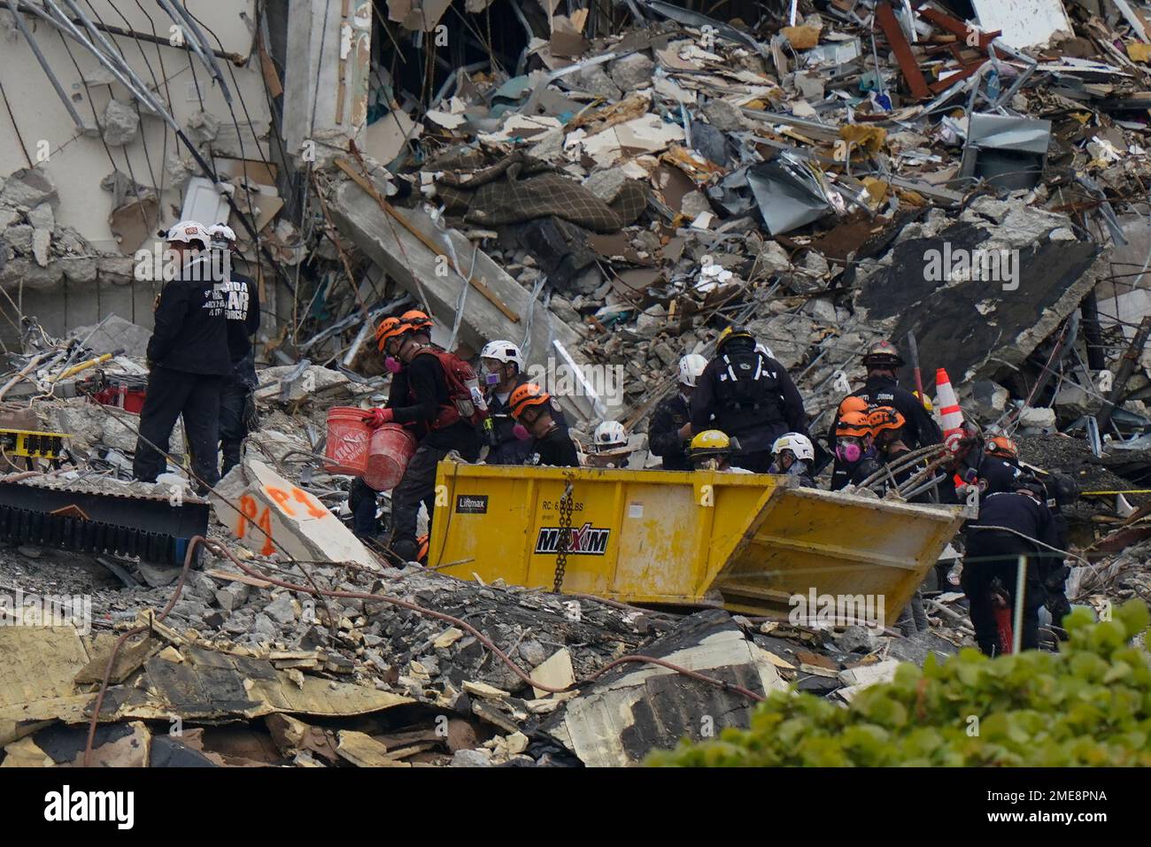 Search and rescue personnel work atop the rubble at the Champlain ...