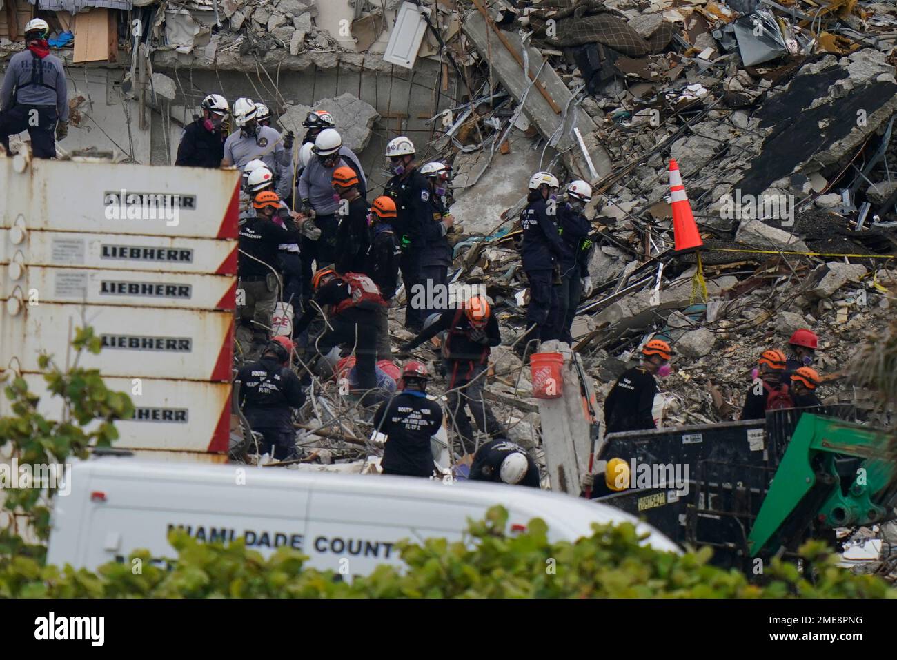 Search and rescue personnel work atop the rubble at the Champlain ...