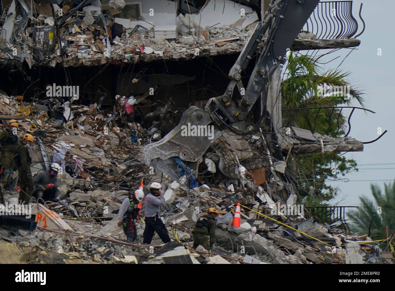 Search and rescue personnel work atop the rubble at the Champlain ...
