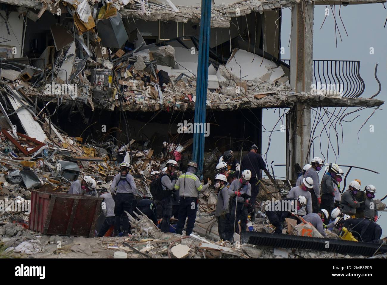 Search and rescue personnel work atop the rubble at the Champlain ...