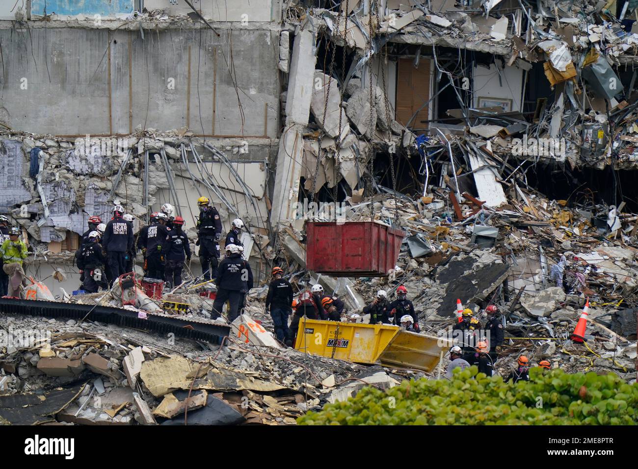 Search and rescue personnel work atop the rubble at the Champlain ...