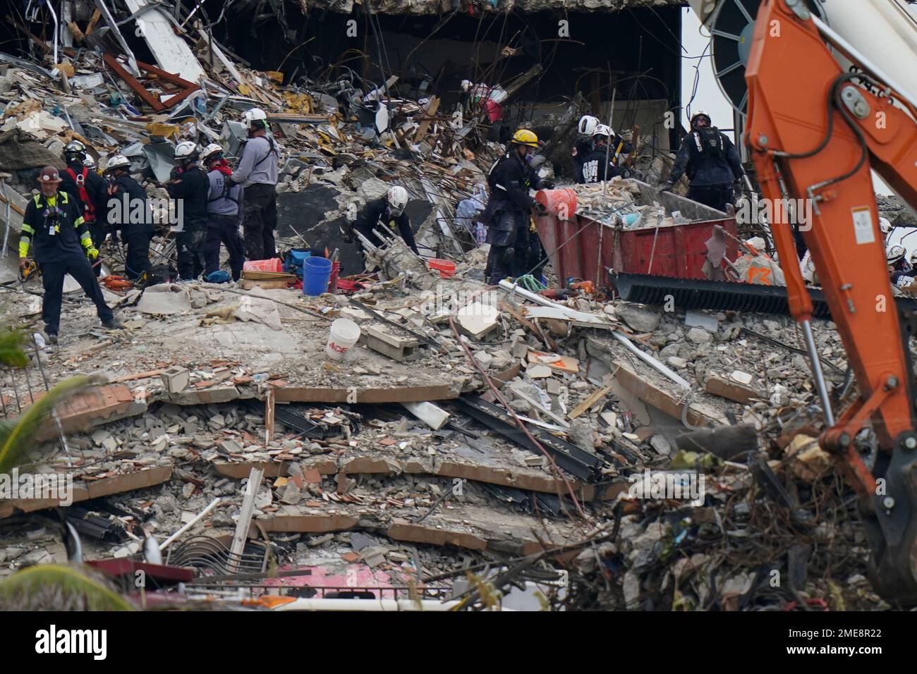 Search and rescue personnel work atop the rubble at the Champlain ...