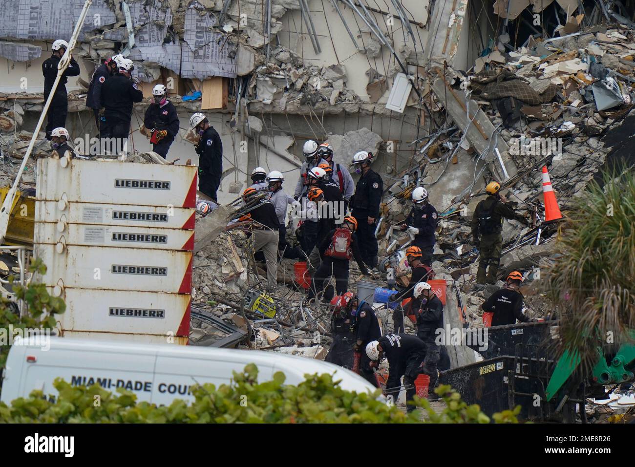 Search and rescue personnel work atop the rubble at the Champlain ...