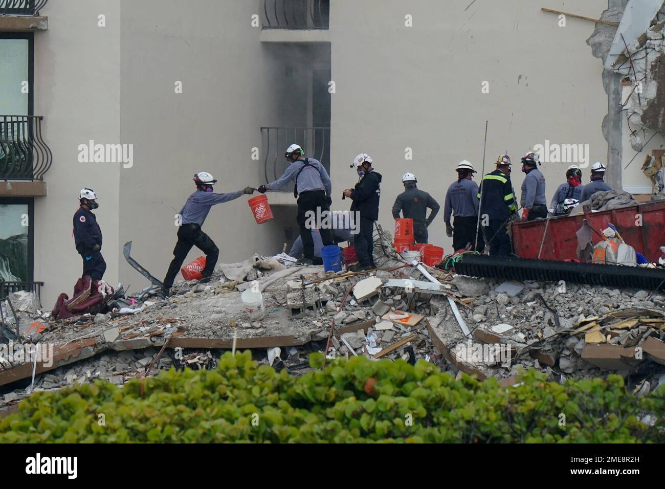 Search and rescue personnel work atop the rubble at the Champlain ...