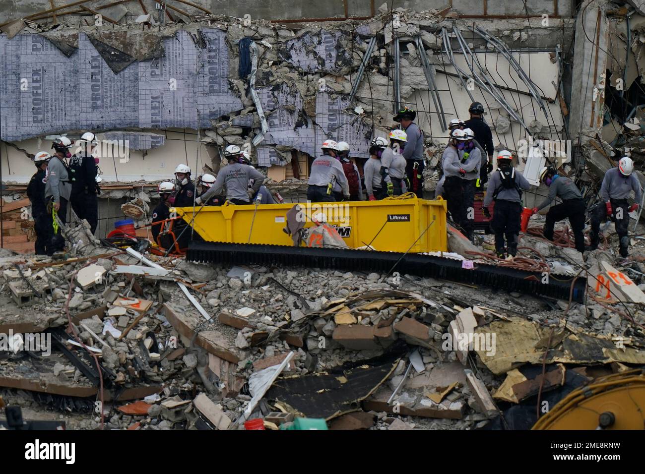 Search and rescue personnel work atop the rubble at the Champlain ...