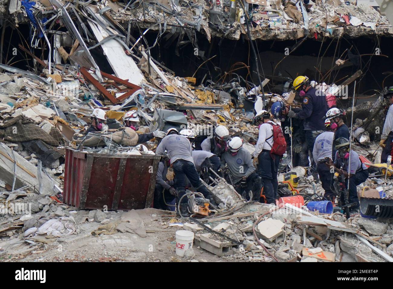 Search and rescue personnel work atop the rubble at the Champlain ...