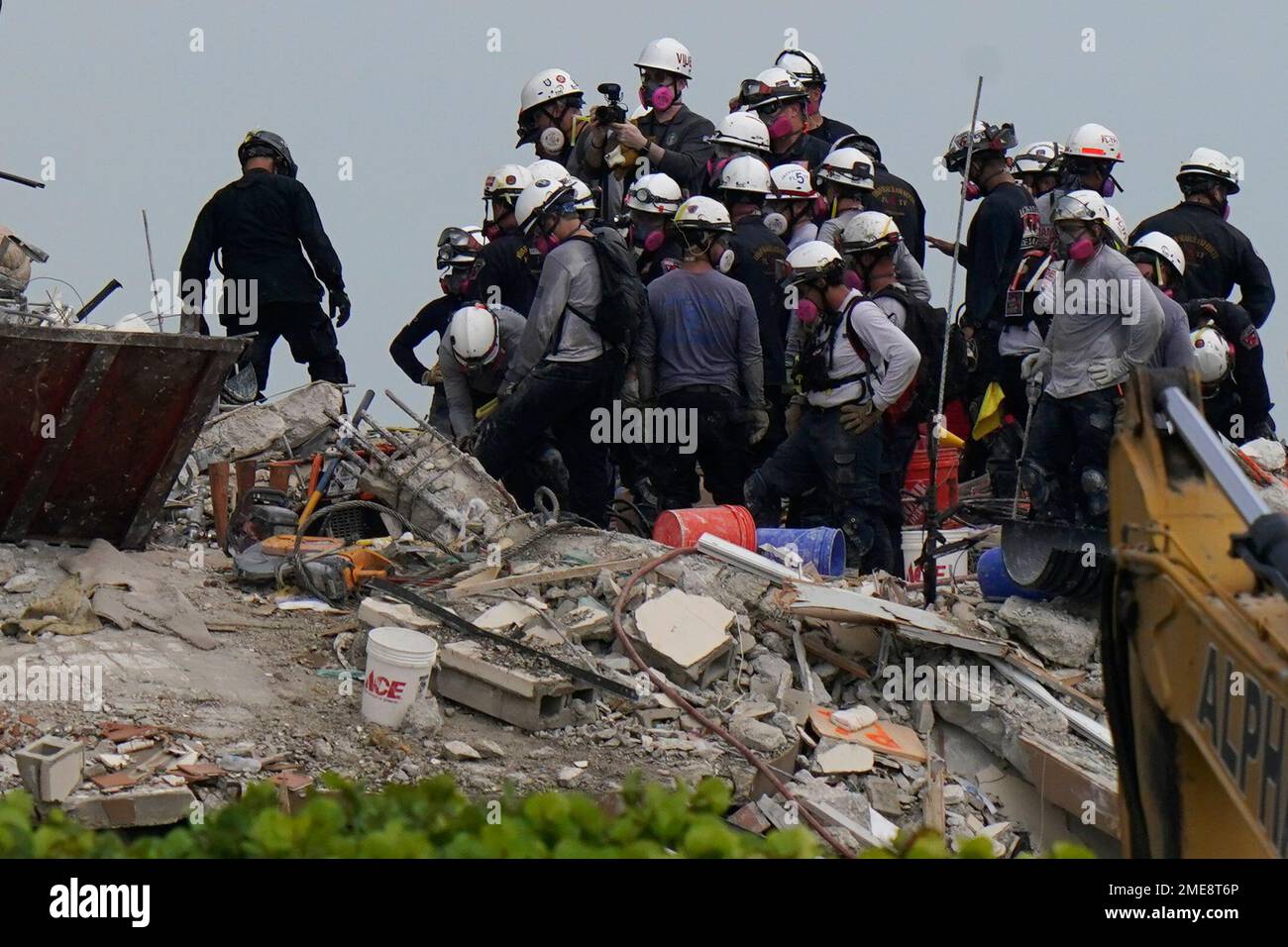 Search and rescue personnel work atop the rubble at the Champlain ...