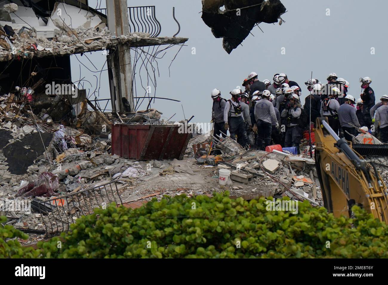 Search and rescue personnel work atop the rubble at the Champlain ...
