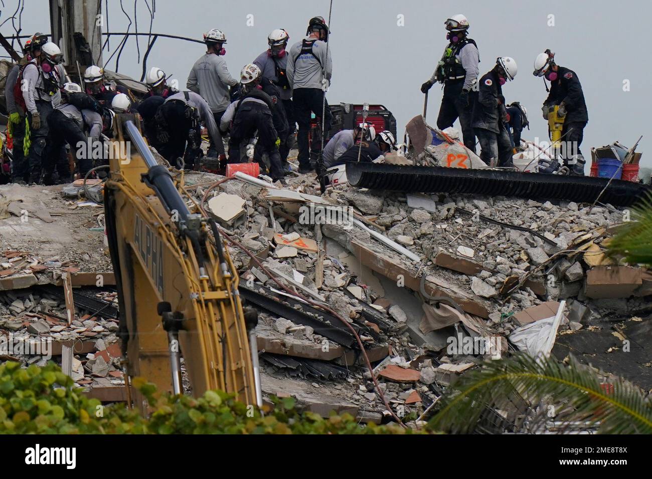 Search and rescue personnel work atop the rubble at the Champlain ...