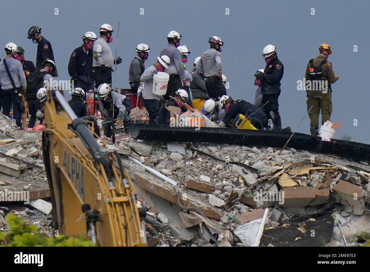 Search and rescue personnel work atop the rubble at the Champlain ...