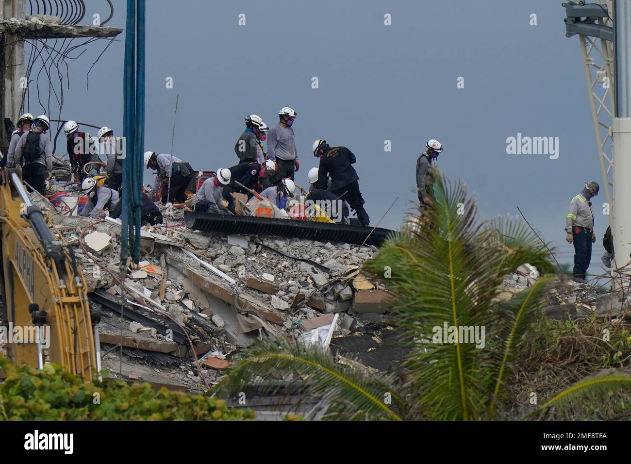 Search and rescue personnel work atop the rubble at the Champlain ...
