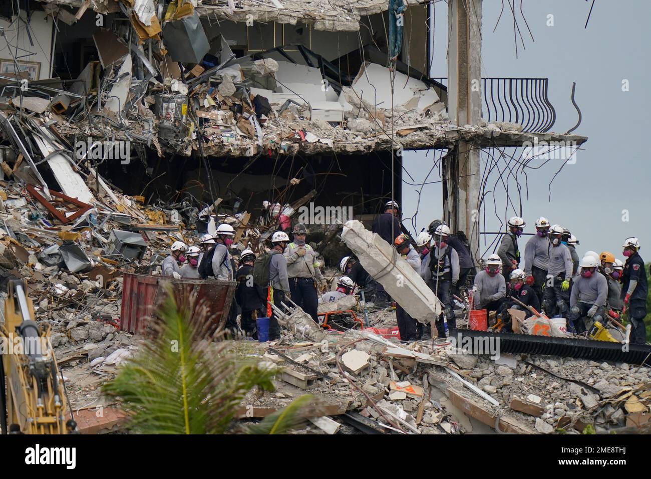Search and rescue personnel work atop the rubble at the Champlain ...