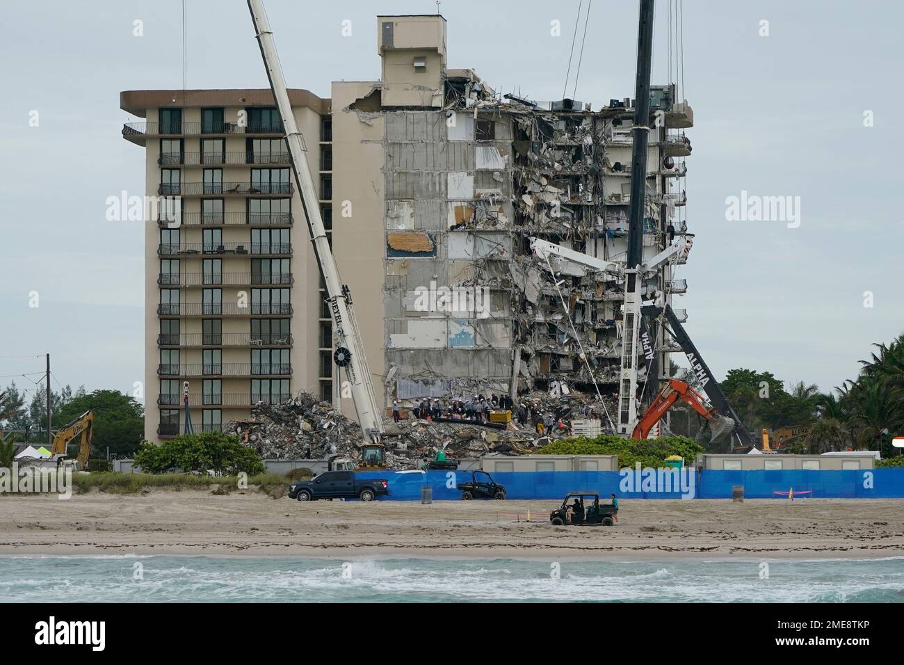 Search and rescue crews work atop the rubble at the Champlain Towers ...