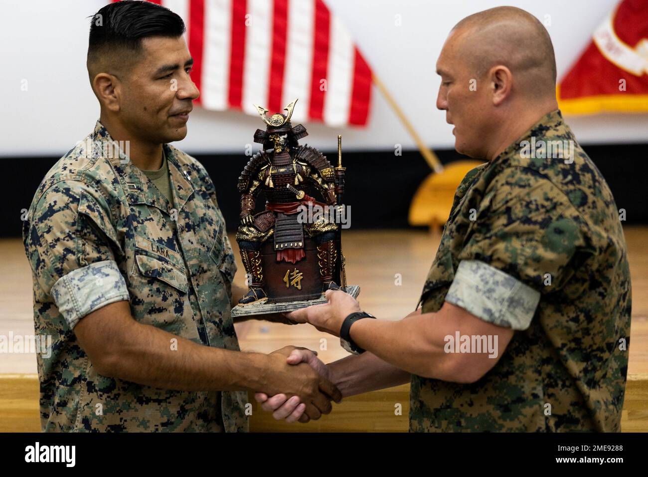 U.S. Marine Corps Lt. Col. Richard Wagner, commanding officer of III Marine Expeditionary Force Support Battalion, III Marine Expeditionary Force, passes on a farewell gift to Capt. Cristobal Lara, the former company commander of Headquarters Service Company, III MSB, III MEF, after a change of command ceremony on Camp Courtney, Okinawa, Japan, Aug. 15, 2022. During the ceremony, Lara relinquished command of HQSVC to Maj. Lance Donald. Stock Photo
