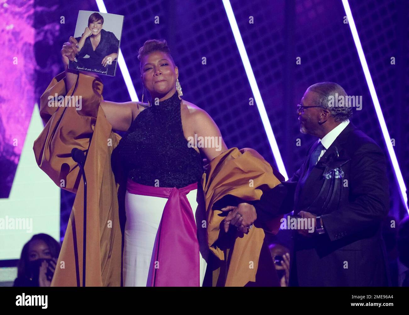 Queen Latifah, winner of the lifetime achievement award, holds a photo