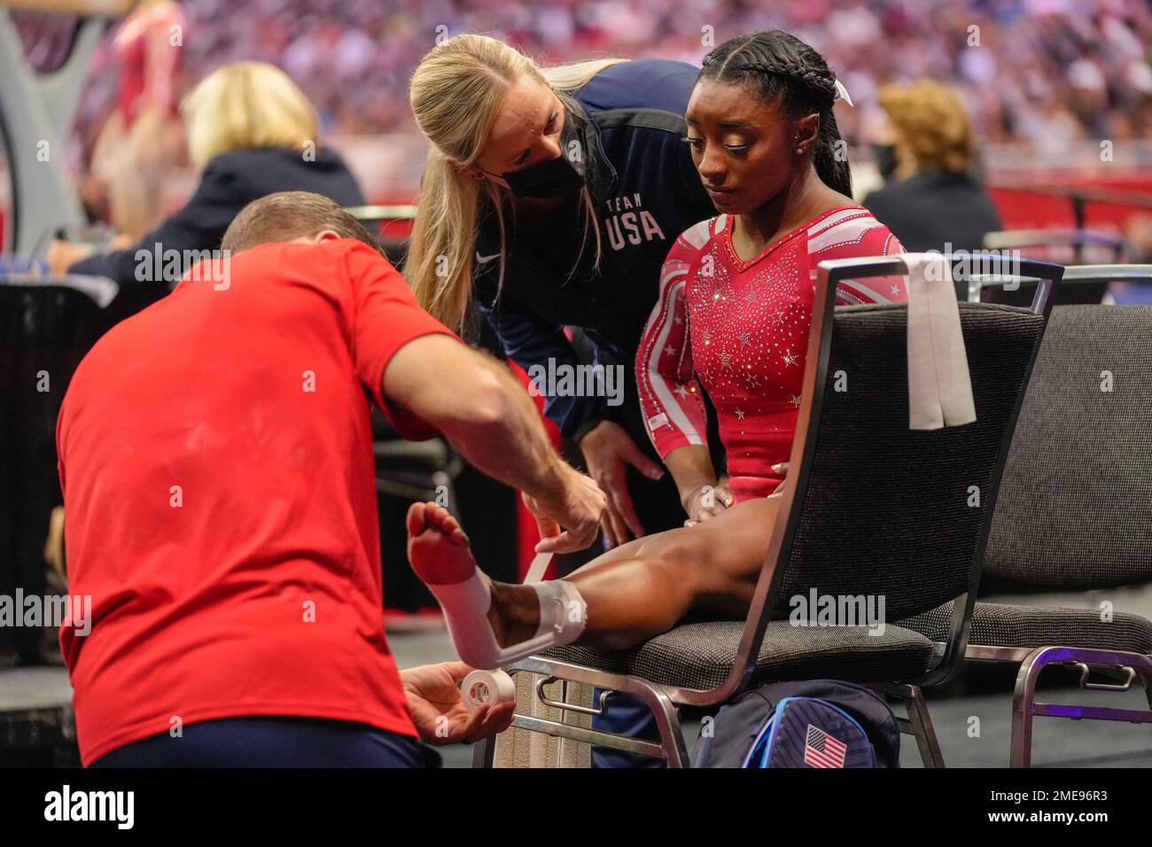 Simone Biles has her ankle taped after falling while competing on the
