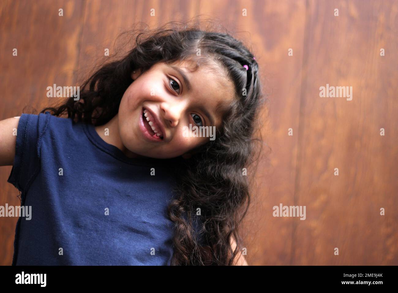 Latina girl with curly hair chews gum that causes tooth decay