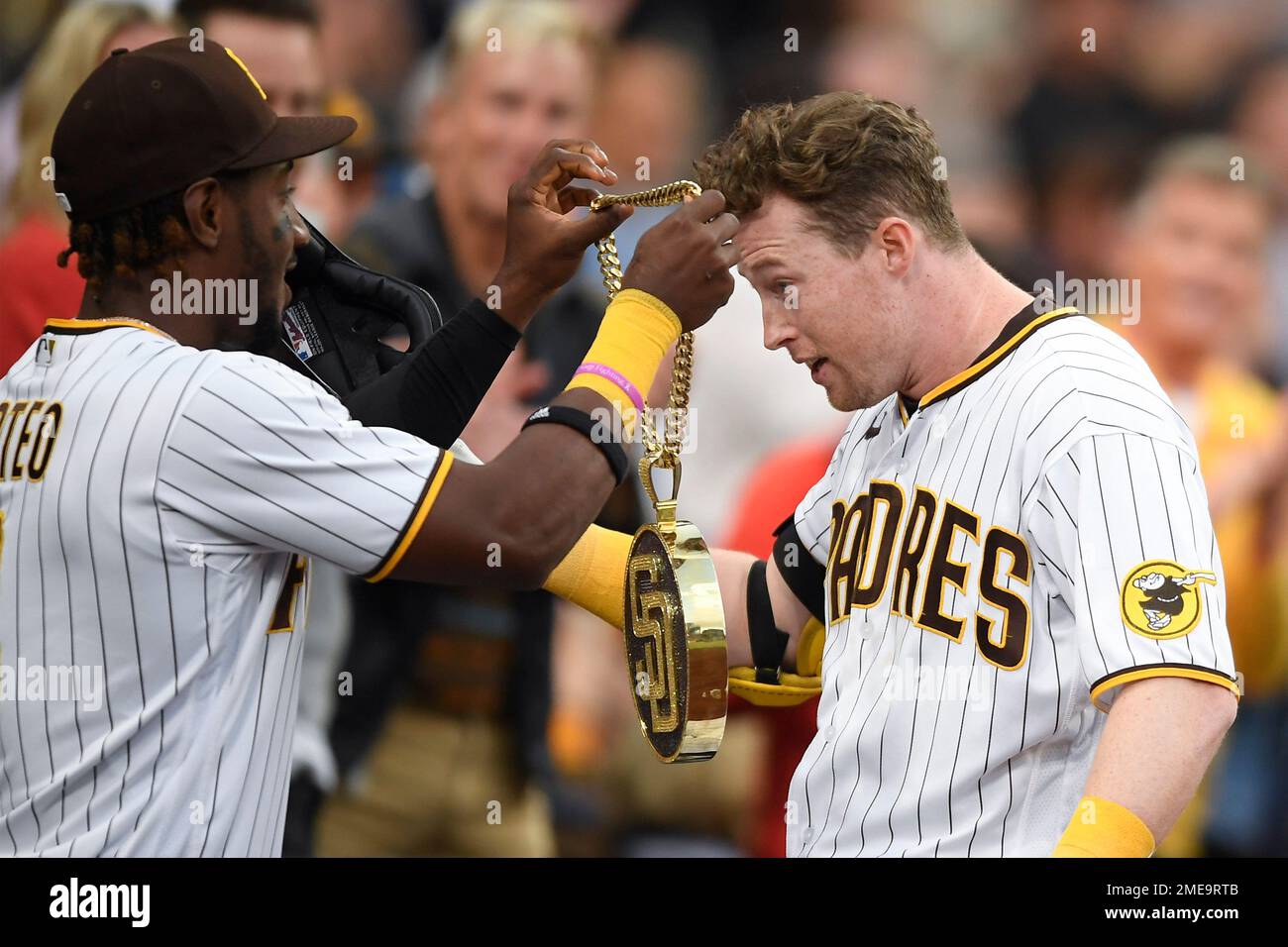 San Diego Padres' Jorge Mateo (3) puts the swag chain on Jake Cronenworth  (9) after he hit a solo home run during the first inning of a baseball game  against the Los