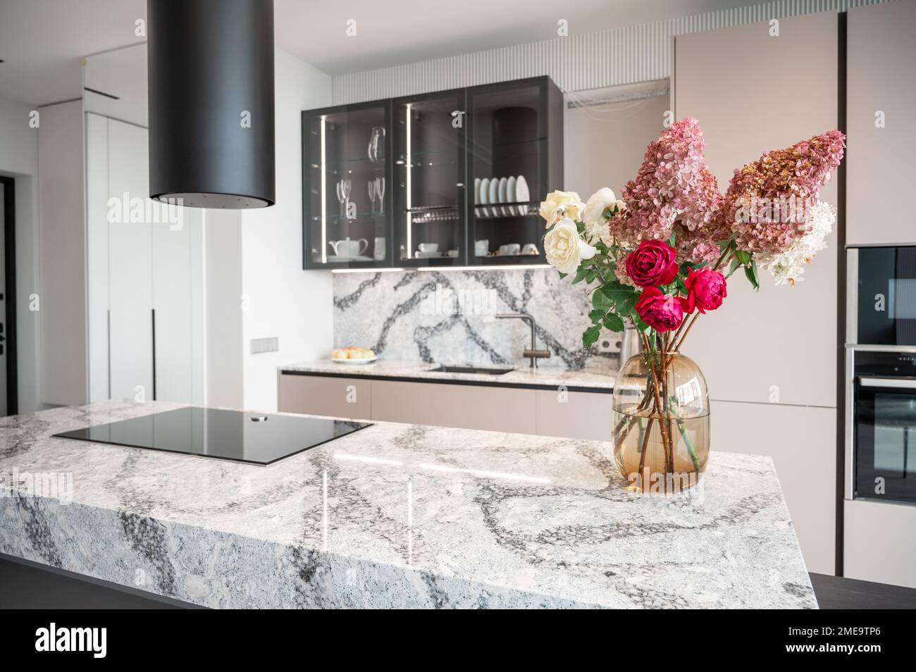 Kitchen in new luxury home with granite quartz table with bouquet of flowers Stock Photo