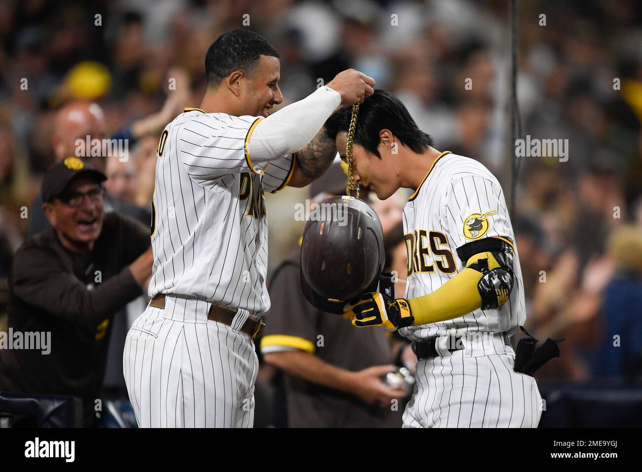 San Diego Padres' Manny Machado (13) puts the swag chain on Ha-Seong Kim  (7) after he hit a solo home run during the fifth inning of a baseball game  against Los Angeles