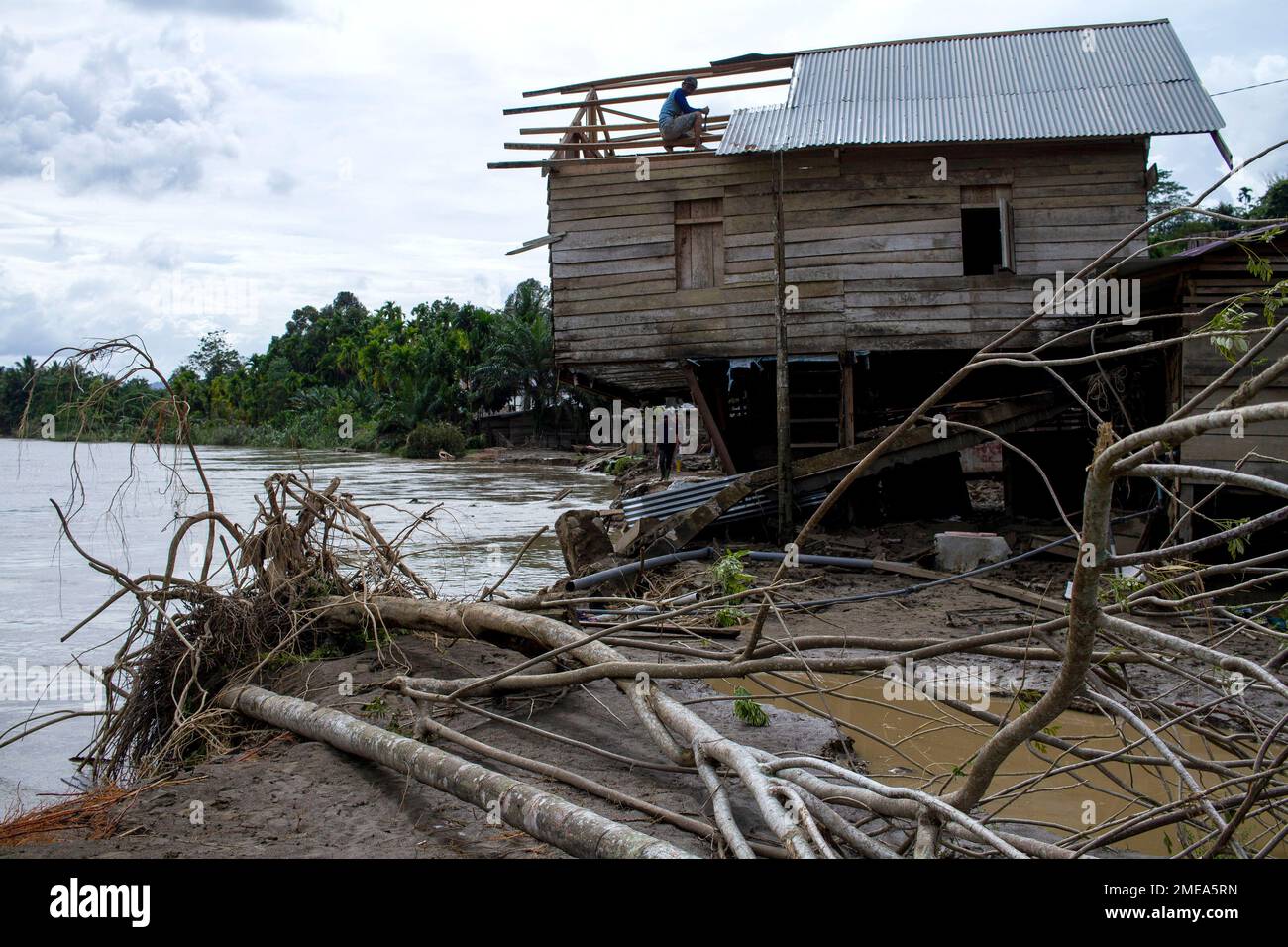Aceh Urara, Indonesia. 23rd Jan, 2023. A man tries to fix the roof of his house damaged by flood water due to heavy rain in Lubok Pusaka village, Aceh Utara district, Aceh Province, Indonesia, Jan. 23, 2023. Credit: Fachrul Reza/Xinhua/Alamy Live News Stock Photo