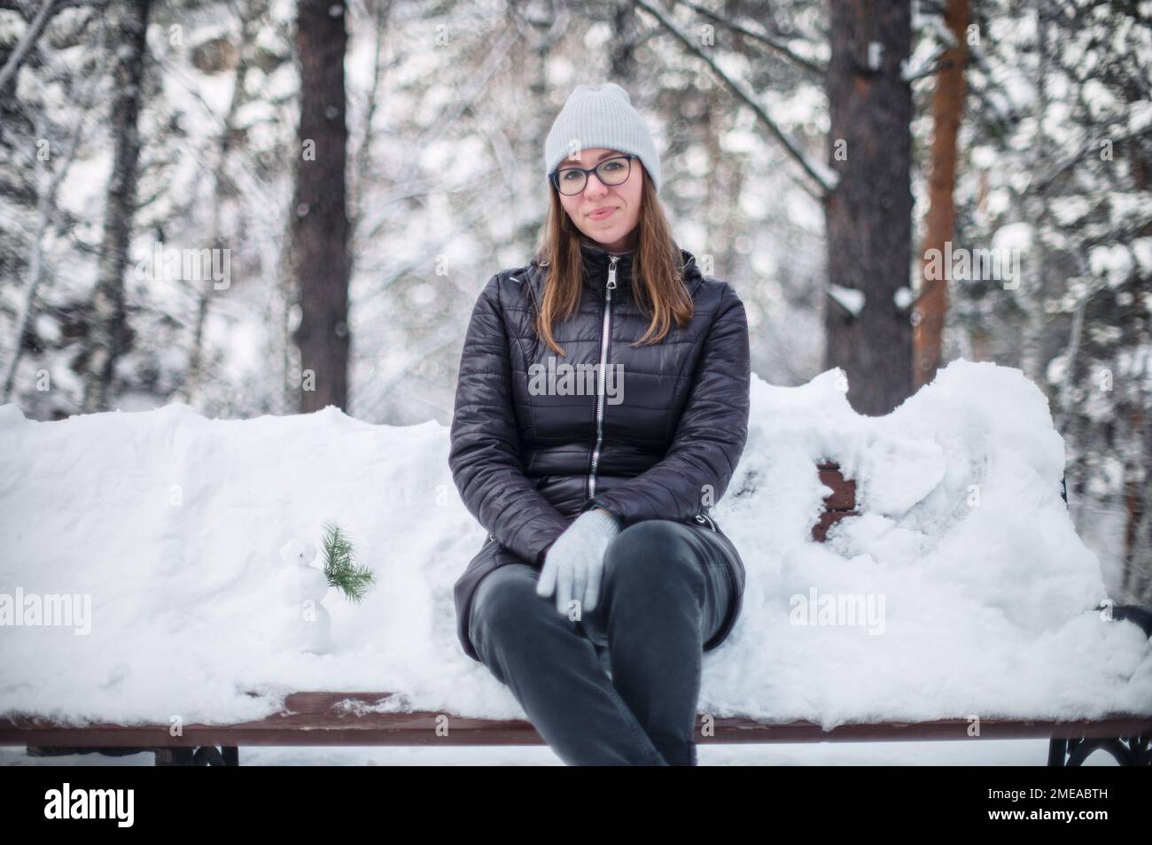 Woman in winter jacket walking in snowy winter forest, snowy winter day. Funny situation, woman fell down and laughs Stock Photo