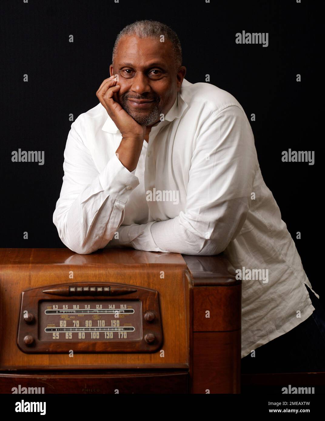 Tavis Smiley, owner of progressive talk radio station KBLA Los Angeles  (1580), poses for a portrait on a vintage AM radio in his station's  offices, Tuesday, June 15, 2021, in Los Angeles.
