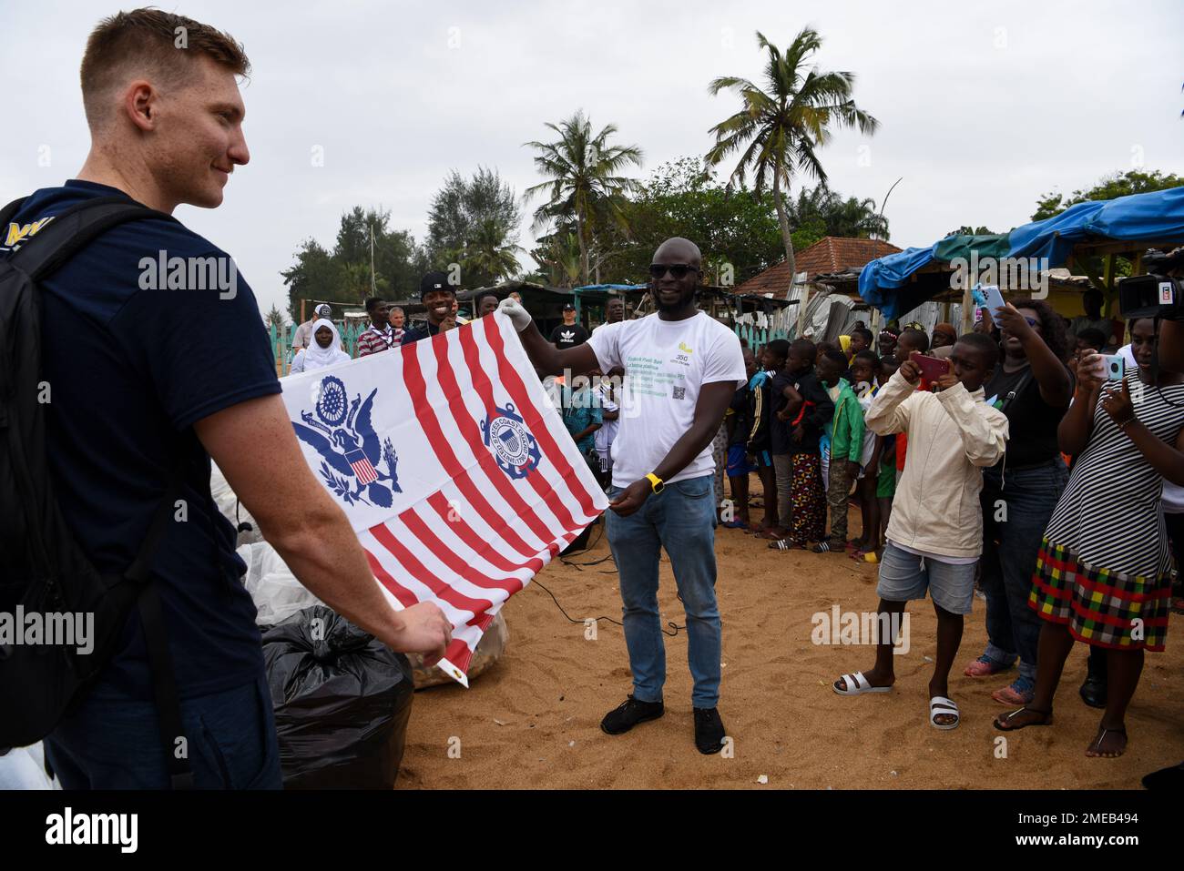 U.S. Coast Guard Ensign Cody Wallace, assigned to the USCGC Mohawk (WMEC 913), presents the Coast Guard Ensign to the director of 350 Côte d’Ivoire after a beach clean-up of Vridi Beach in Abidjan, Côte D’Ivoire, Aug. 15, 2022. Mohawk is on a scheduled deployment in the U.S. Naval Forces Africa area of operations, employed by U.S. Sixth Fleet to defend U.S., allied, and partner interests. Stock Photo
