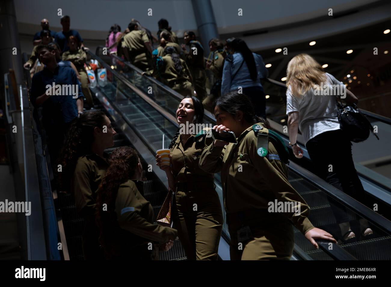 People ride an escalator at a shopping mall after restrictions