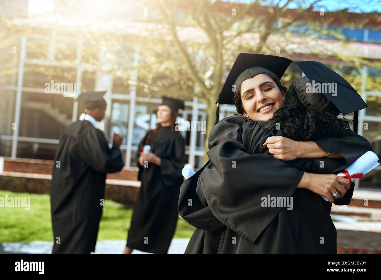 We always said wed make far. two happy young women hugging on ...