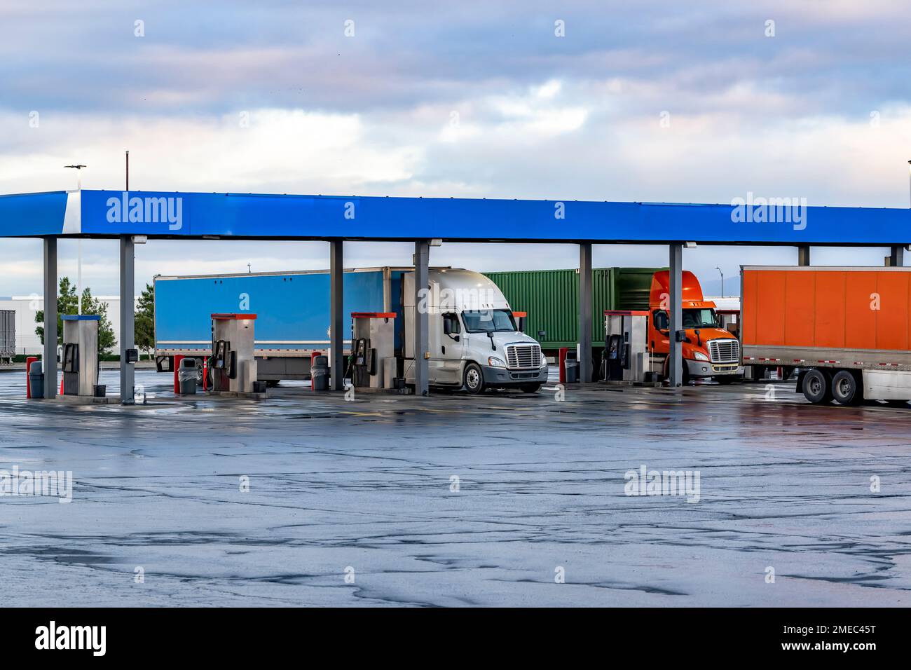 Industrial standard big rigs semi trucks with semi trailers standing on ...