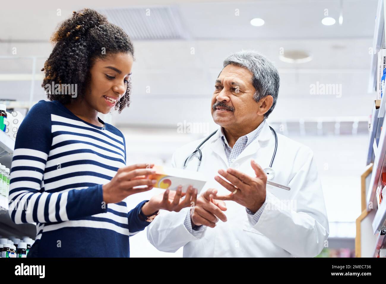 Take this daily until your symptoms clear. a pharmacist assisting a young woman in a chemist. Stock Photo