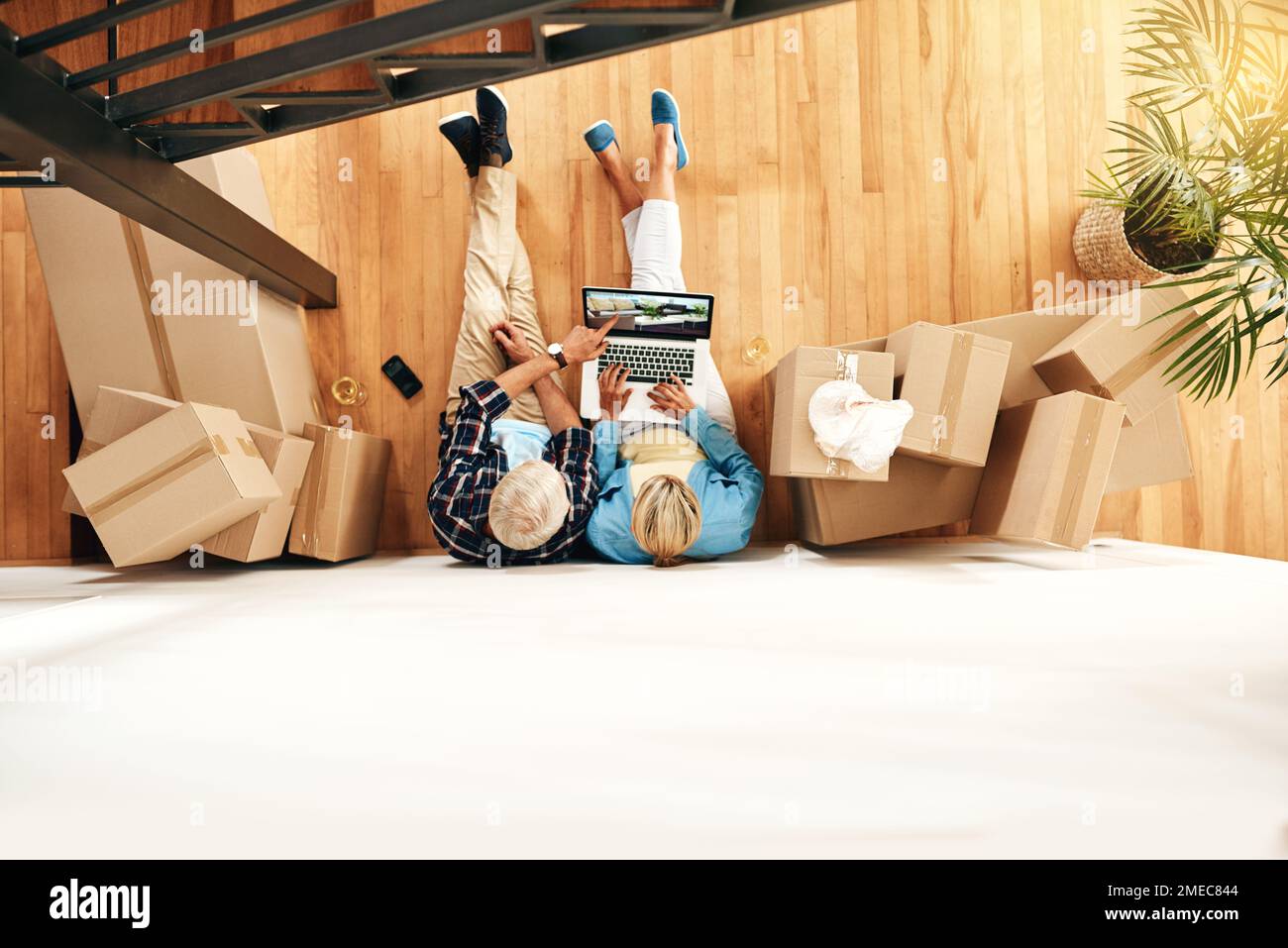 The internet is a great place for interior design inspiration. High angle shot of a mature couple using a laptop together on moving day. Stock Photo