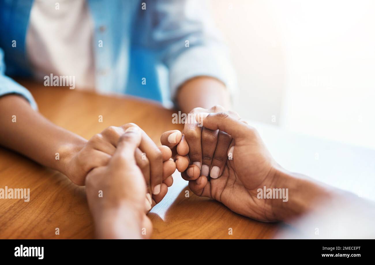 Together we can overcome anything thrown our way. Closeup shot of two unrecognizable people holding hands in comfort at home. Stock Photo