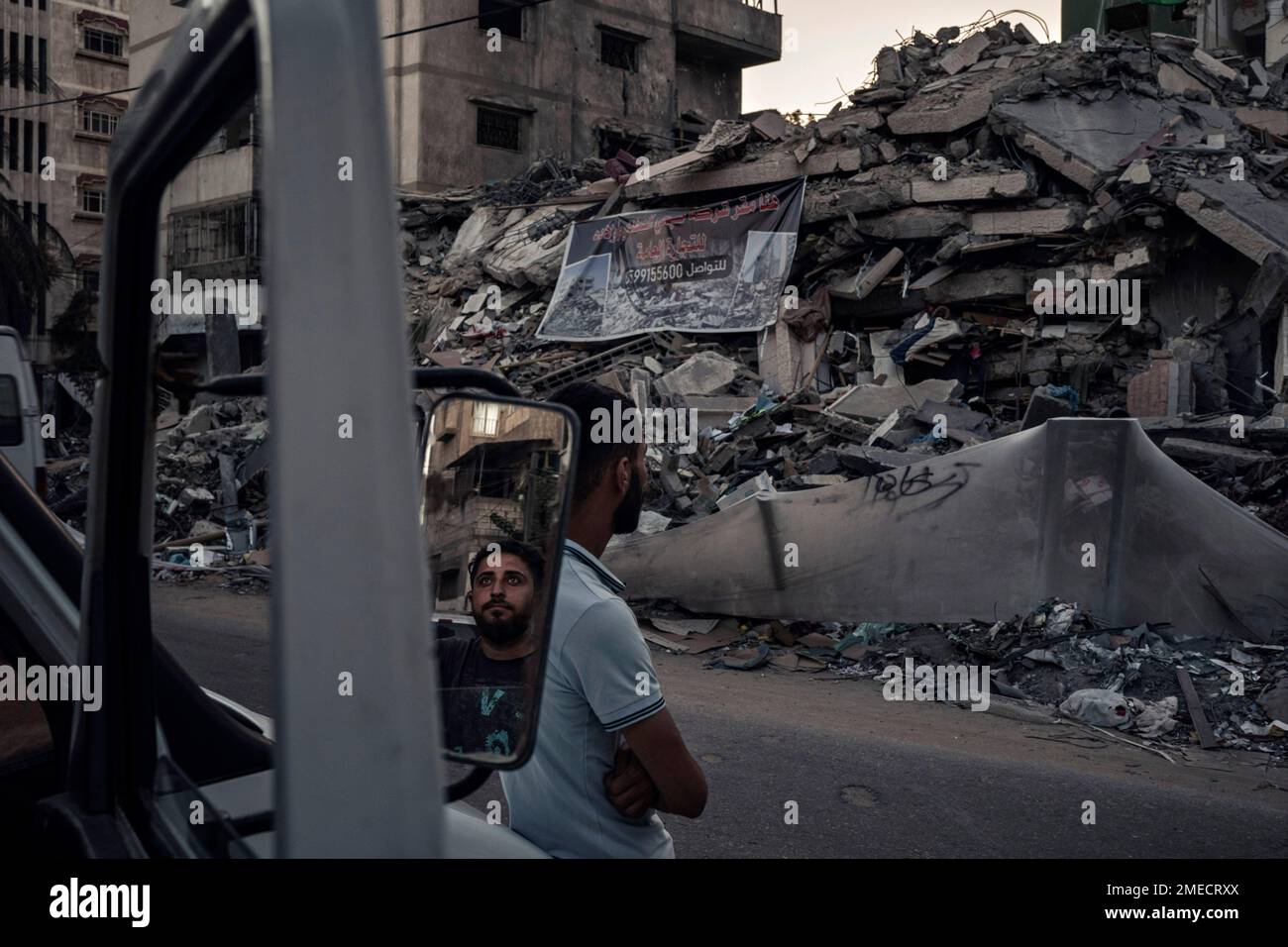 Palestinians look at the rubble of a building that collapsed after it ...