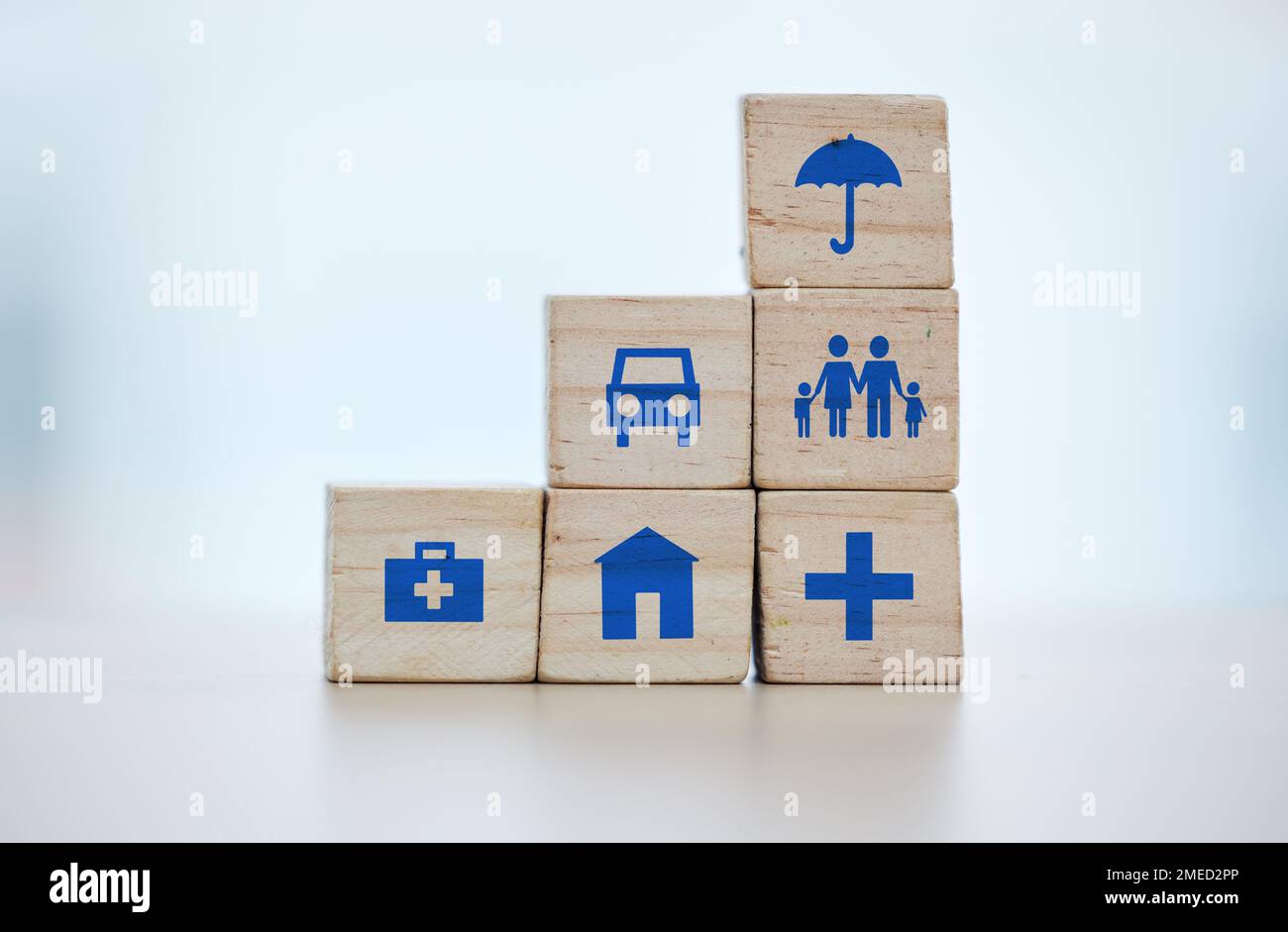 Building blocks of medical, house and life insurance cover on blurred background for family, safety and healthcare icon. Goals, risk management and Stock Photo