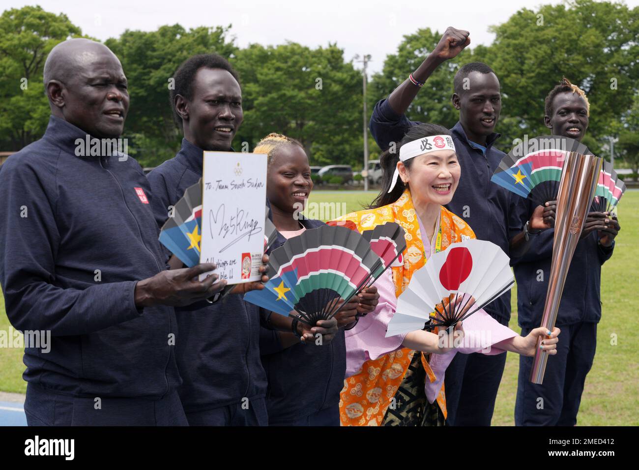 Olympic fan Kyoko Ishikawa, center, takes a photo with South Sudan athletes who have been train for the Tokyo 2020 Olympics and Paralympics in Maebashi, Gunma Prefecture, north of Tokyo Thursday, June 3, 2021. Ishikawa, who carried the Olympic torch in Toyama Prefecture a day before, came to cheer on the South Sudanese team as an unofficial "International Olympic Cheerleader" marking the 50 day countdown to the Olympics start. (AP Photo/Eugene Hoshiko) Stock Photo