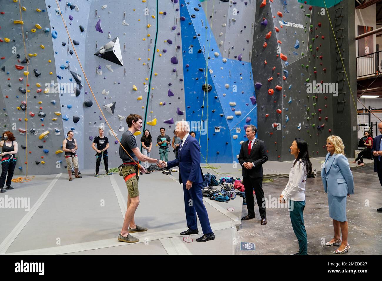 President Joe Biden shakes hands with a climber as he, first lady Jill