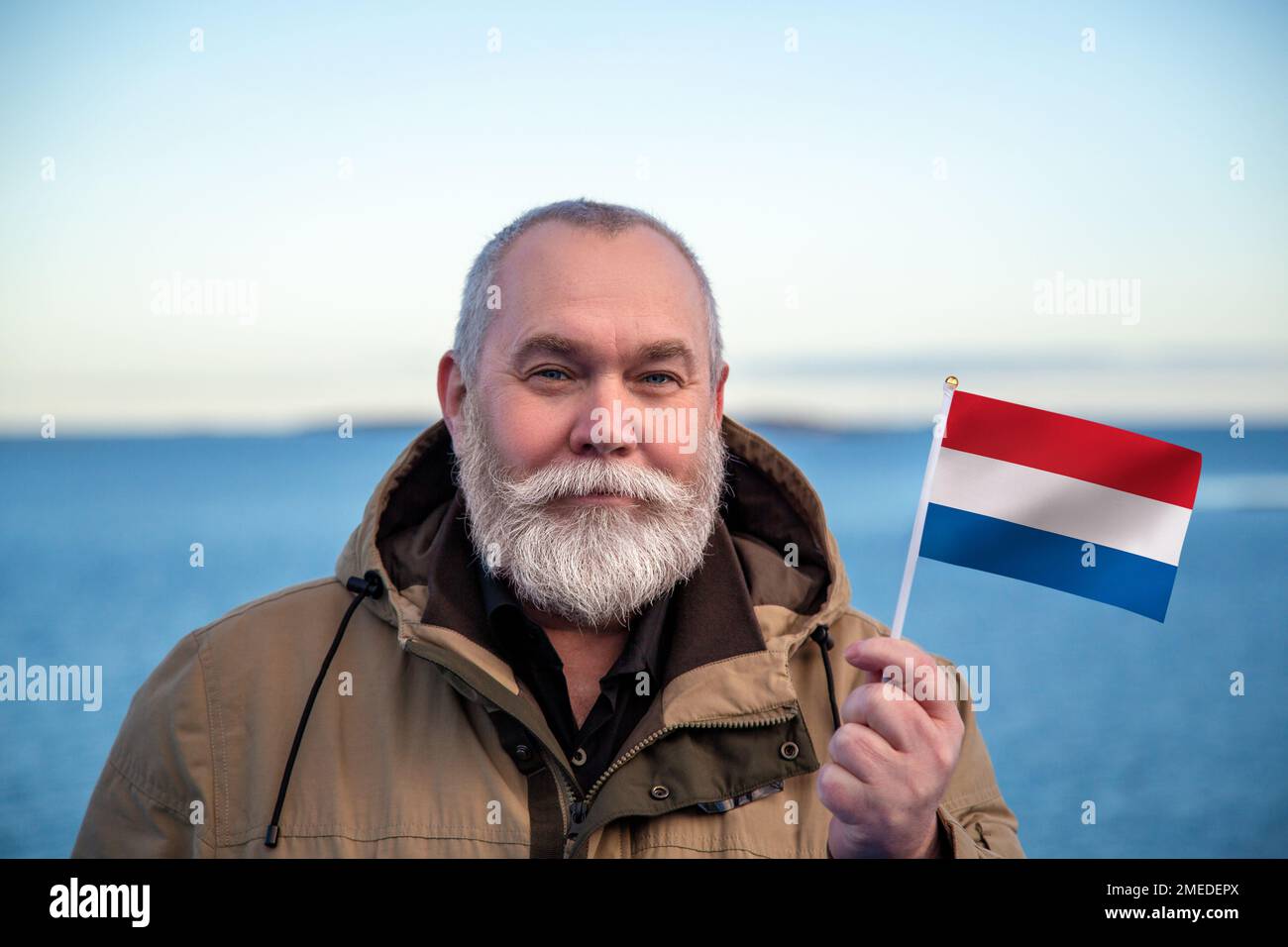 Man holding Netherlands flag. Portrait of older man with a national