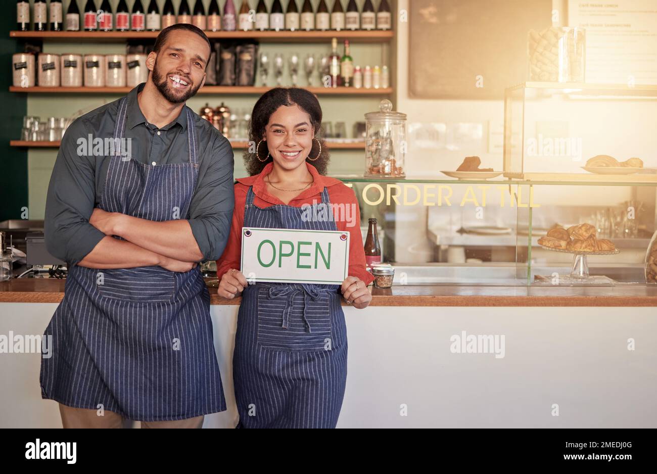Cafe, portrait or happy couple with an open sign to sales with hospitality at a coffee