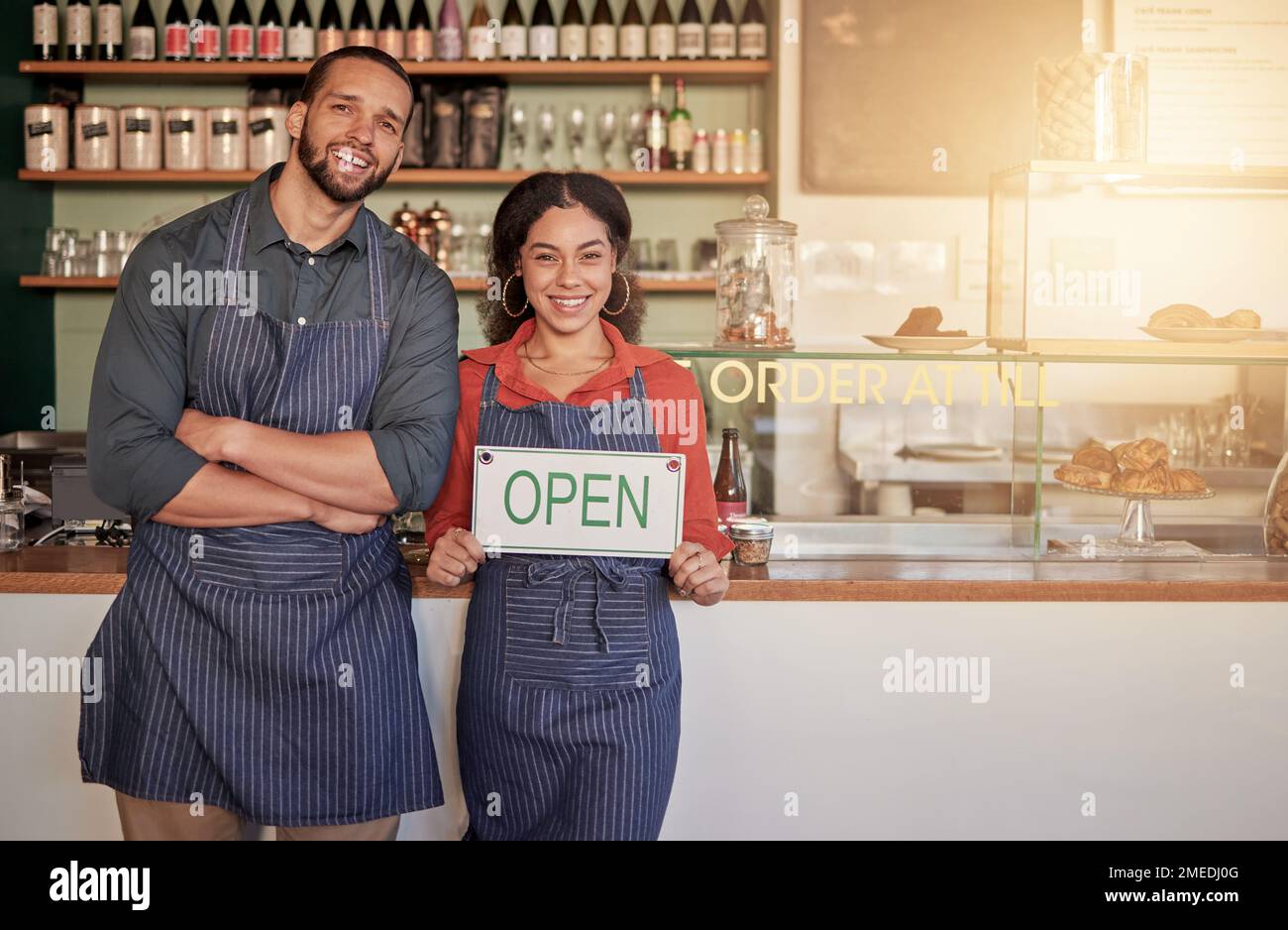 Cafe, portrait or happy couple with an open sign to welcome sales with hospitality at a coffee shop. Manager, partnership or entrepreneurs smile Stock Photo