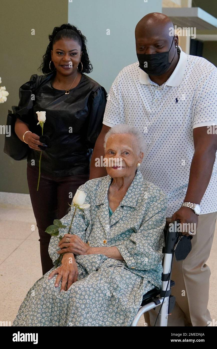 Viola Fletcher, center, the oldest living survivor of the Tulsa race massacre, holds a rose she