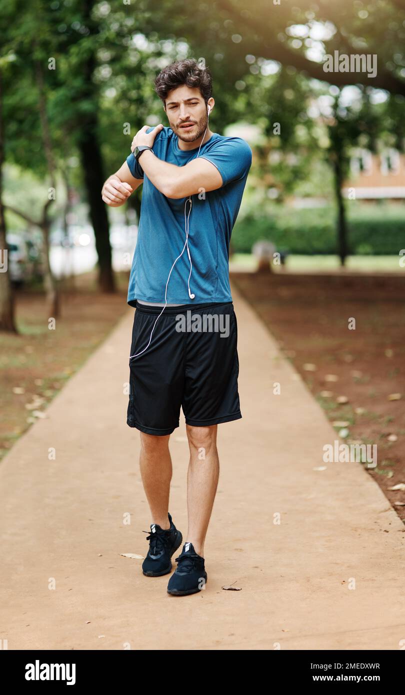 I should see someone about this shoulder. a sporty young man holding his shoulder in pain while exercising outdoors. Stock Photo