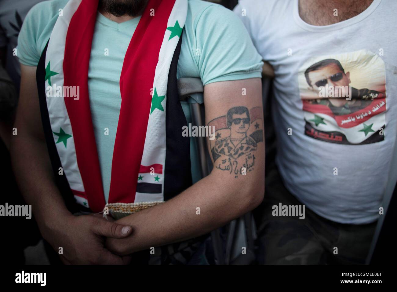 An Injured Syrian soldier with a tattoo of President Bashar Assad as they  celebrate at Omayyad Square, in Damascus, Syria, Thursday, May 27, 2021.  (AP Photo/Hassan Ammar Stock Photo - Alamy, image size:1300x956