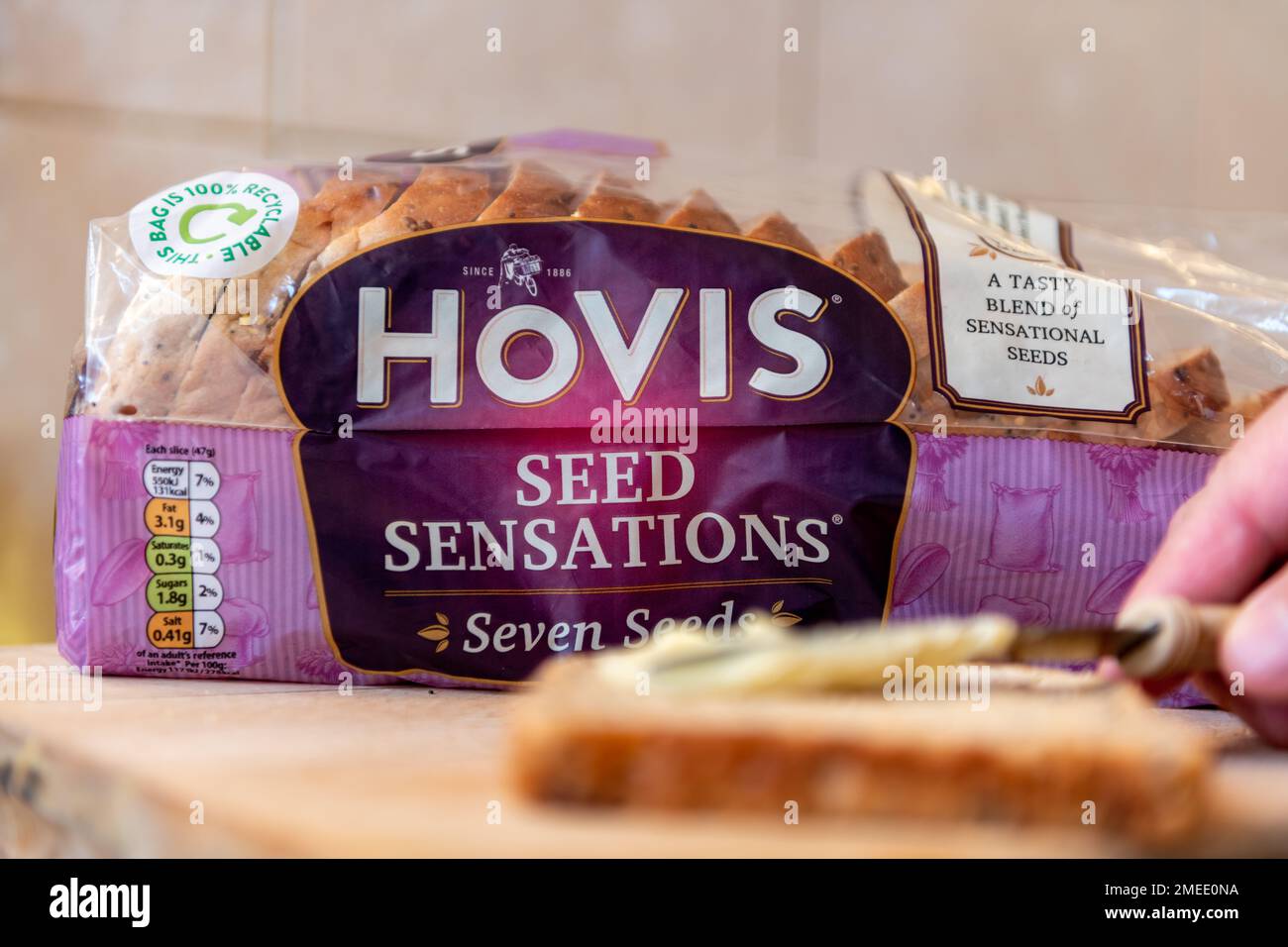 London. UK- 01.22.2023.A package loaf of Hovis Seed Sensation bread on a kitchen wooden board. Stock Photo
