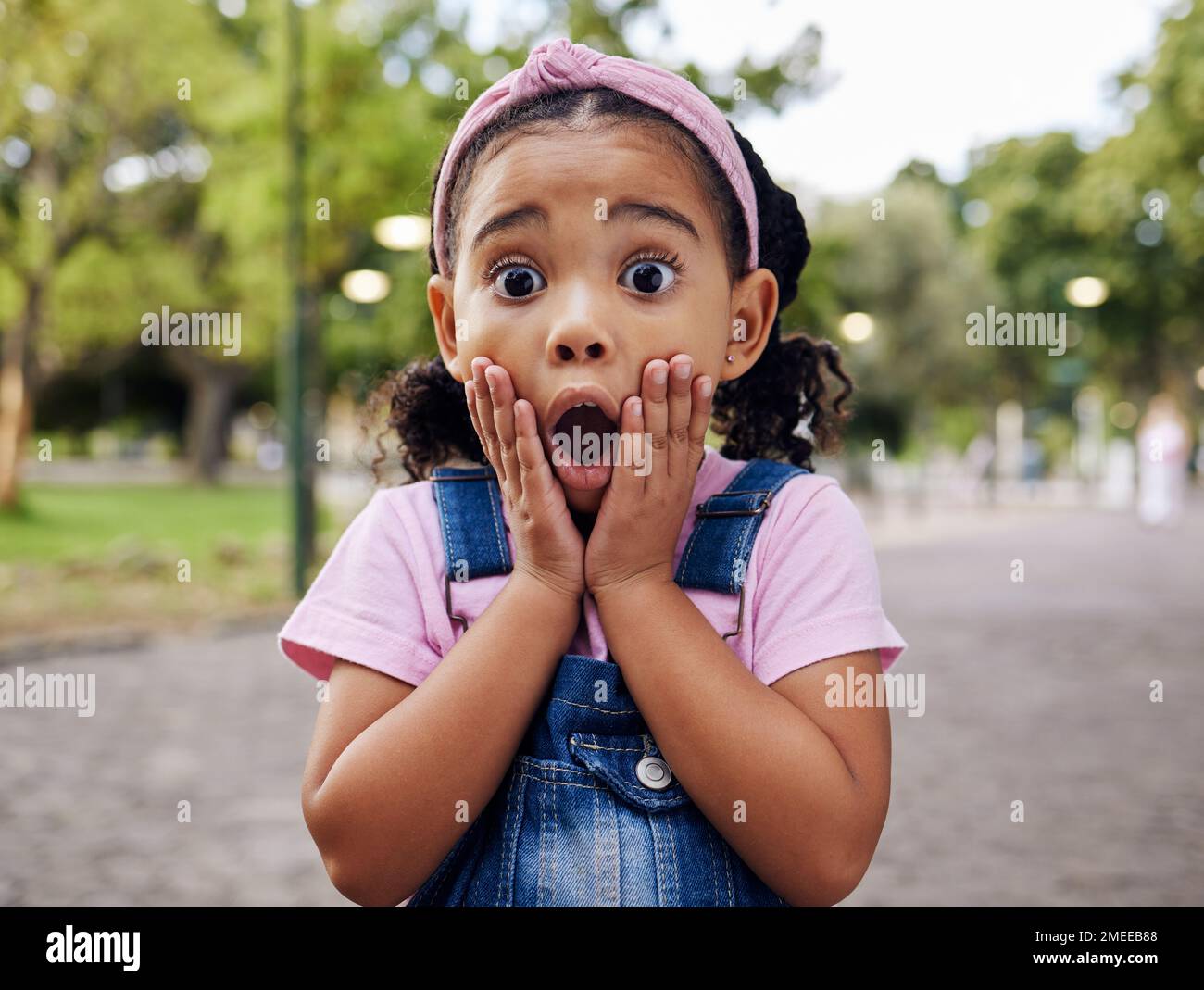 Wow, surprise and girl child at park outdoors looking shocked. Face portrait, omg and shock of kid from South Africa with surprised facial expression Stock Photo