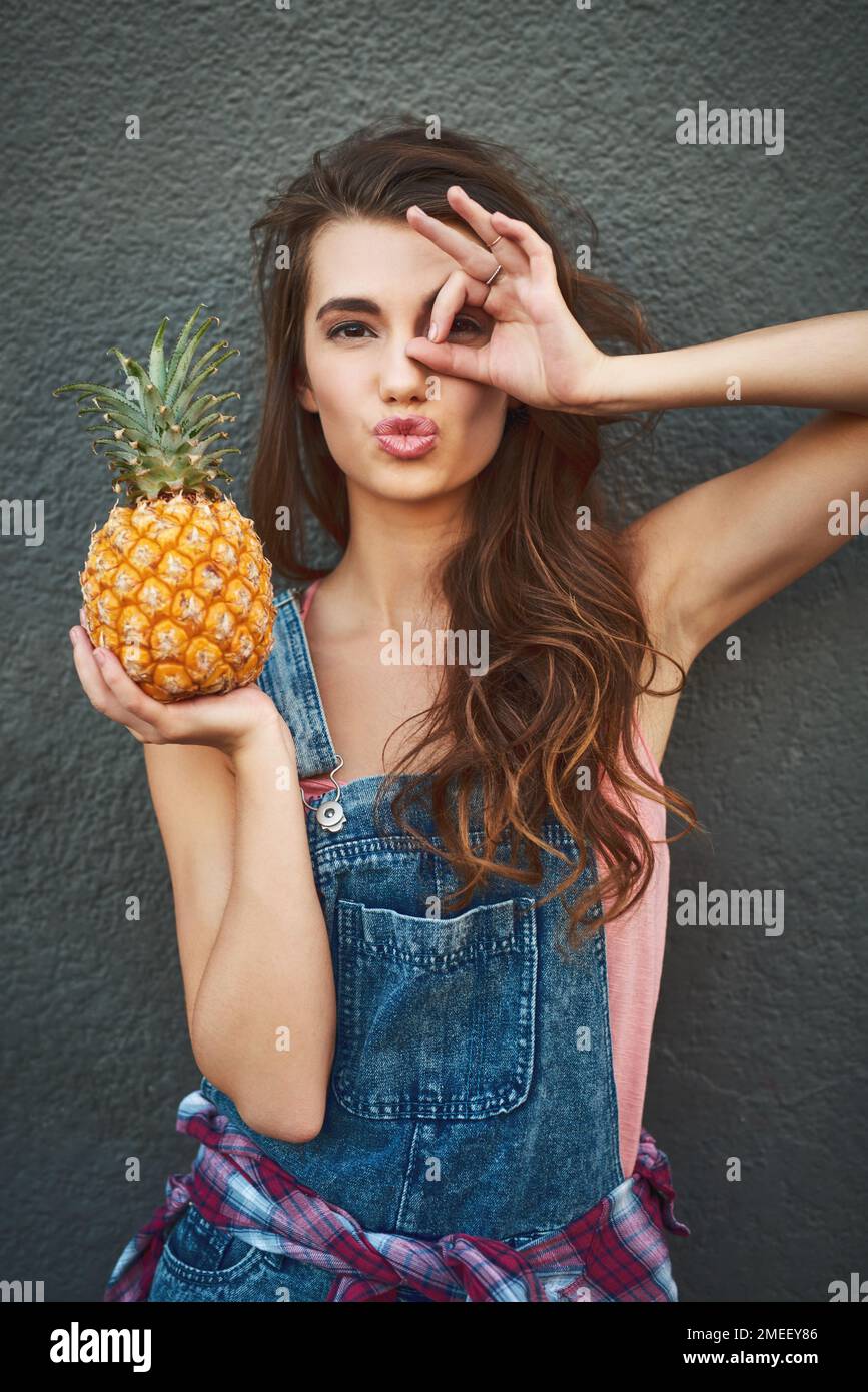 I only see pineapples today. Portrait of a carefree young woman showing